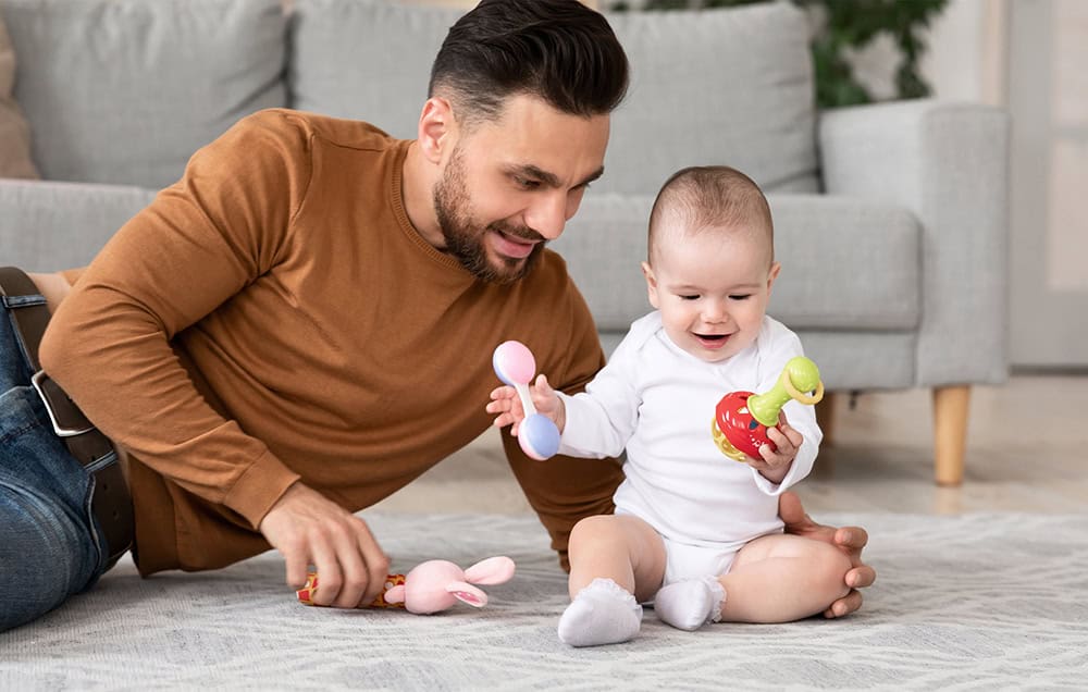 Papá y su bebé jugando en el suelo